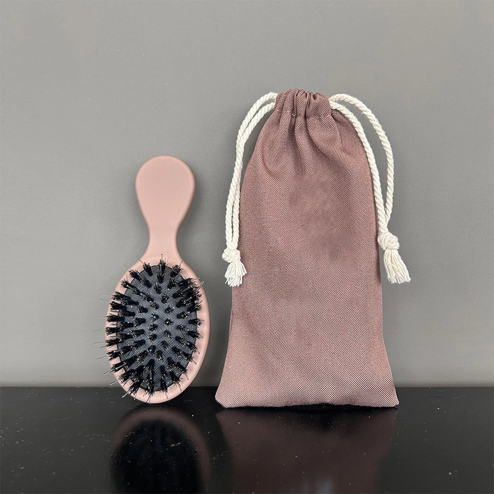 A set of matte boar bristle hair extension brushes in dusty rose color, shown against a gray background.