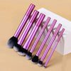 A set of ten professional makeup brushes with metallic pink handles and black bristles displayed on a white box.