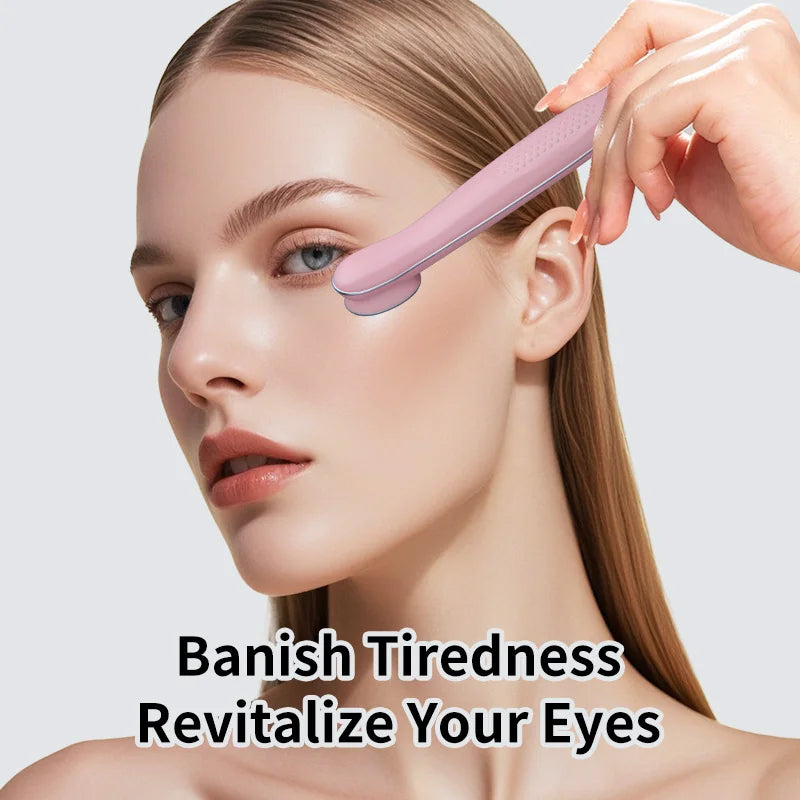 A hand is using a pink eye massager wand on a woman's eye area to revitalize the skin.