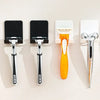Quatre crochets muraux pour ranger des rasoirs, outils de coiffure noir et blanc.