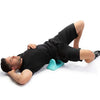 A man lying on his stomach receiving deep tissue massage with a psoas muscle massager.