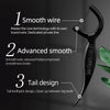A black dental floss stick with a tail design is shown next to green leaves.