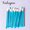A collection of 50 thin, blue and white disposable lip applicator brushes arranged vertically on a light purple background.
