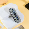 A folding pocket hair comb with a mirror and scalp massage cushion displayed on a white block.