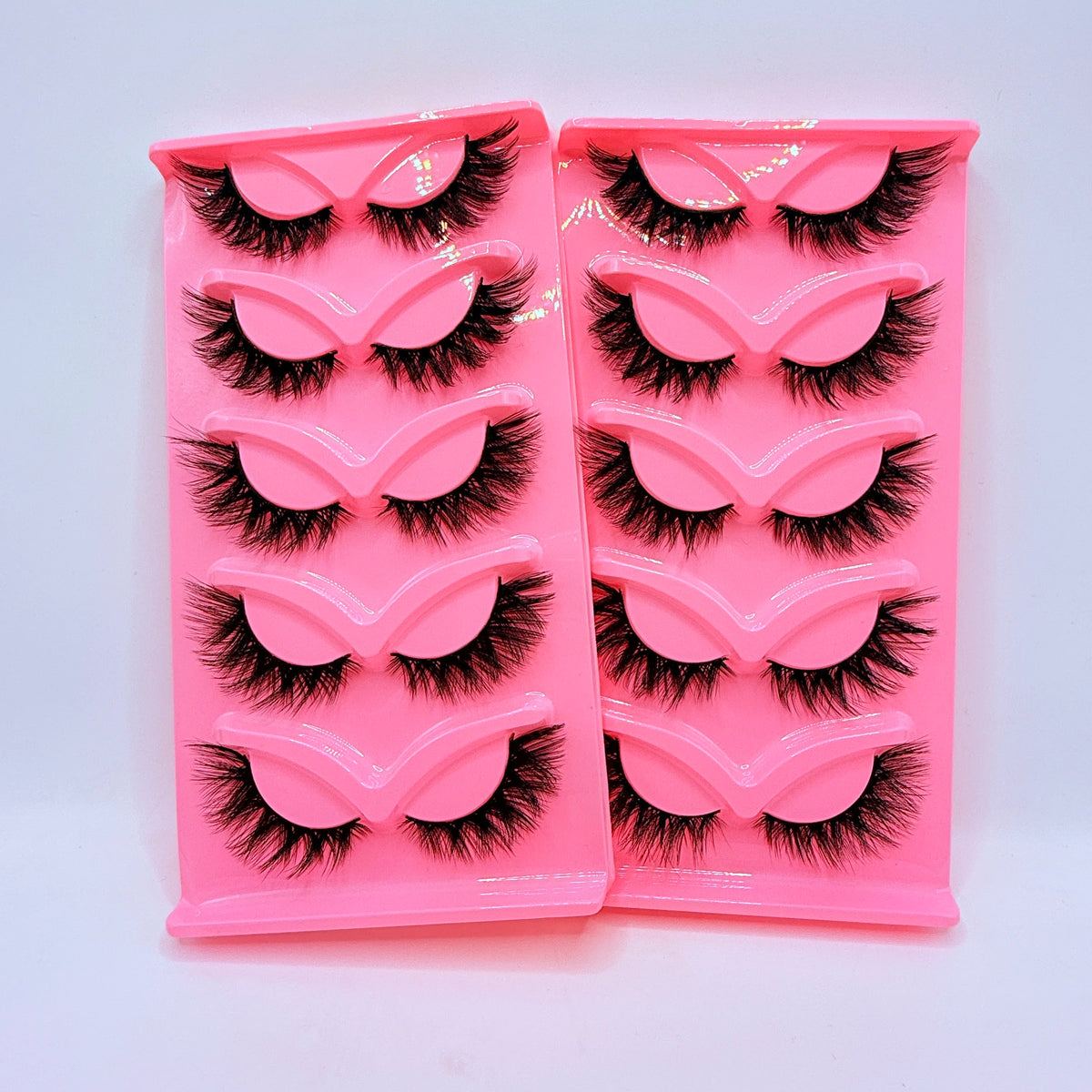Plateau en plastique rose contenant cinq paires de faux cils dramatiques.