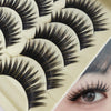 Close-up of a false eyelash strip showcasing long, thick black lashes on a cosmetic palette.