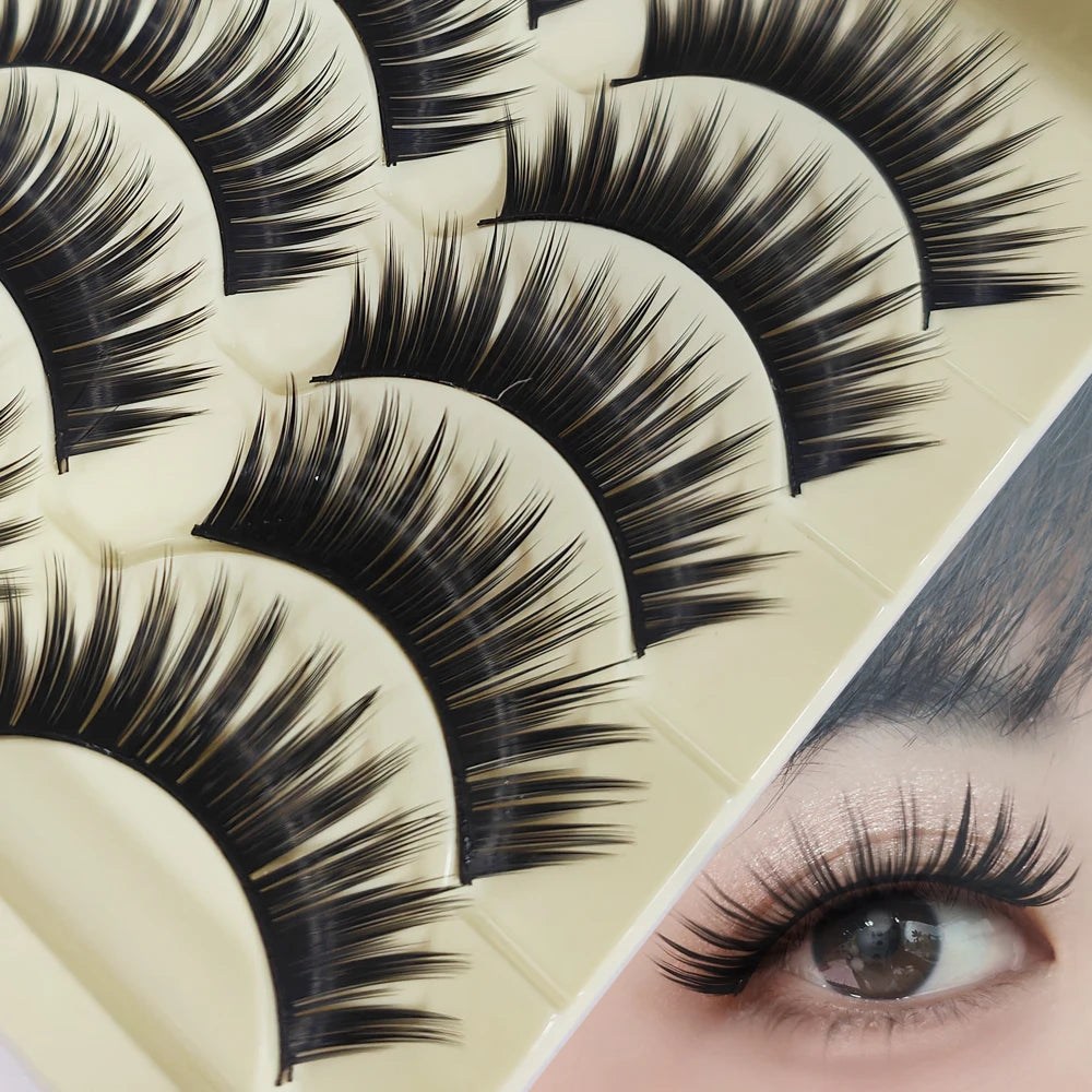 Close-up of a false eyelash strip showcasing long, thick black lashes on a cosmetic palette.