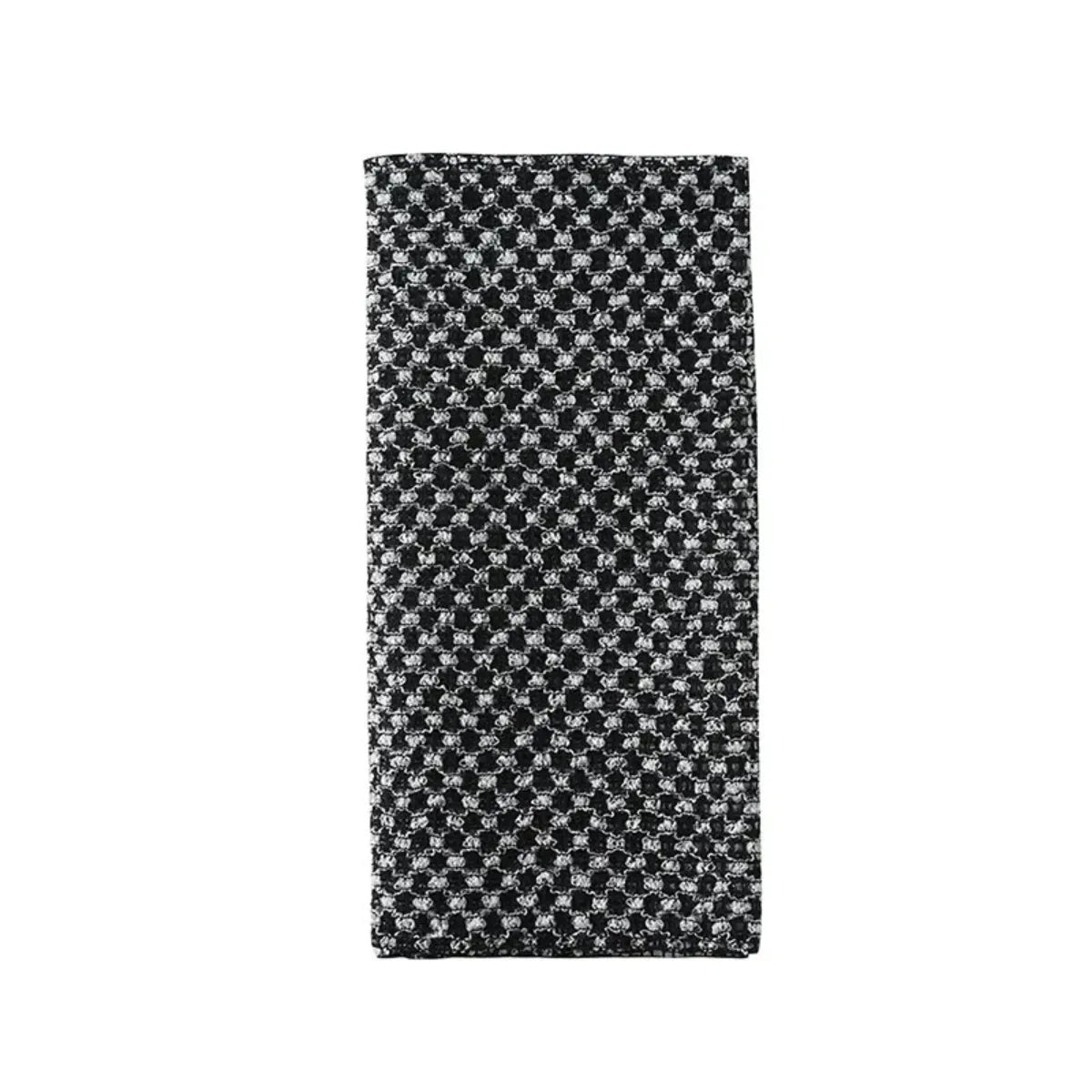 A rectangular loofah scrubber with a black and white patterned design.