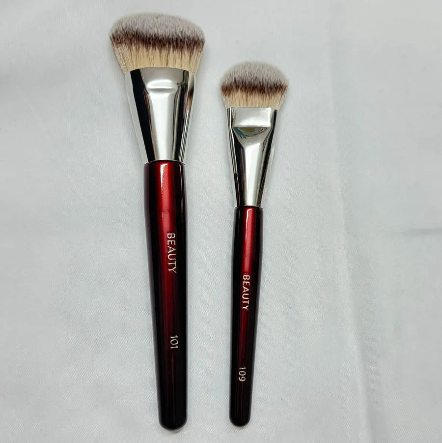 Unie de maquillage à liquide inclinée avec ferrules argentées et têtes de pinceaux douces.