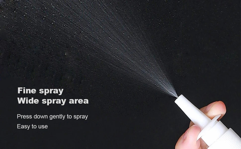 A hand is gently pressing a white nasal spray bottle to create a fine mist spray area.