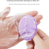 A hand is using a purple silicone facial cleansing brush to foam and remove deep dirt from the skin.
