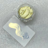 A small glass jar of light yellow glitter powder next to a white swatch showing the product's color and texture.