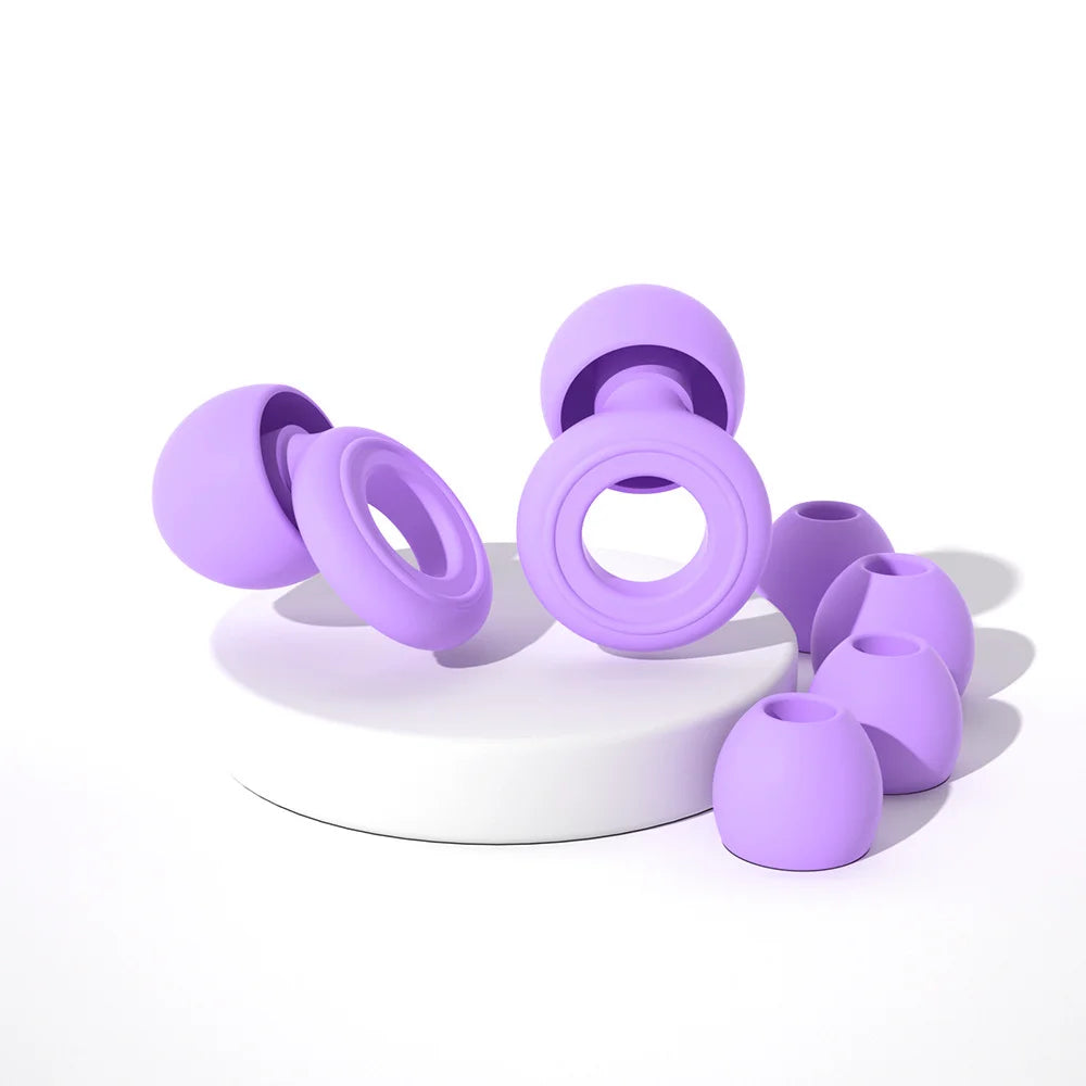 A collection of purple silicone earplugs, including various sizes and shapes, displayed on a white surface.