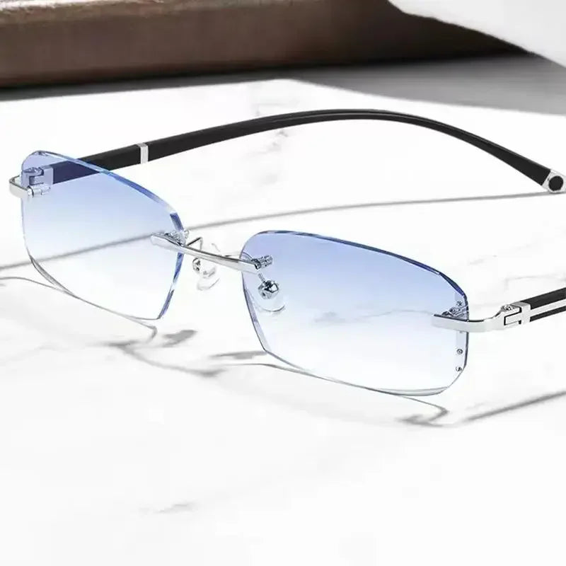 Pair of blue photochromic reading glasses with black frames resting on a white marble surface.