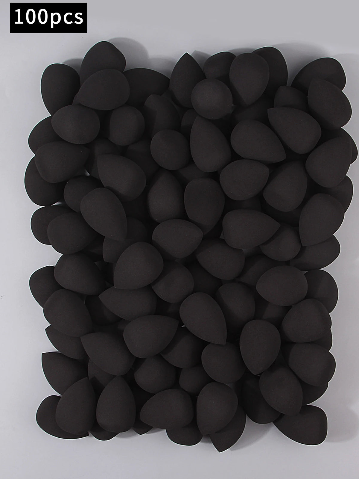 Pila de 100 esponjas de maquillaje negras multifacéticas para una aplicación impecable.