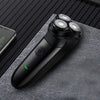 A black intelligent rechargeable electric shaver rests on a gray textured surface.