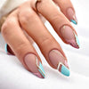 Close-up of a hand displaying press-on false nails with a French wavy design featuring pink and light blue accents.
