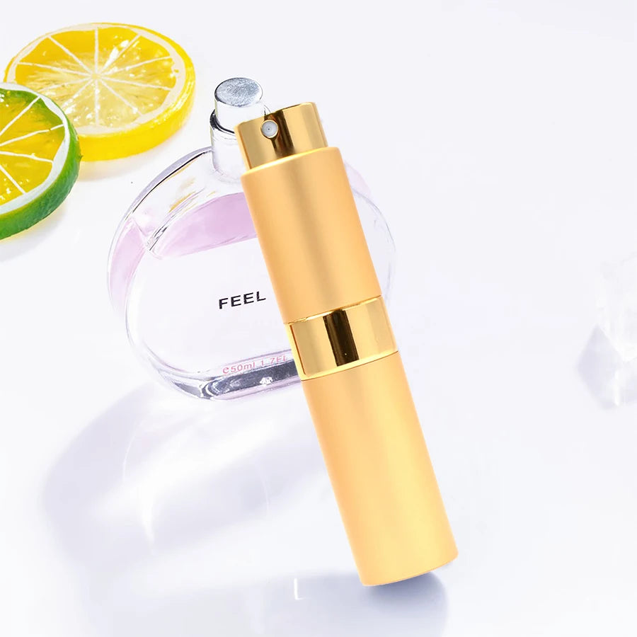 Flacon de parfum couleur or à côté d'une bouteille en verre et de tranches de citron et de lime.