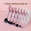 A set of seven pink makeup brushes displayed in a white box.