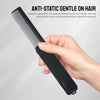 Une main tient un peigne anti-statique noir à dents fines, démontrant son utilisation sur les cheveux.