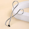 Stainless steel wide-angle eyelash curler tool resting on a white surface.