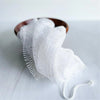 White reusable exfoliating bath sponge washcloth with a white string attached