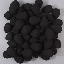 A pile of 50 black multi-sided makeup sponges for flawless application.