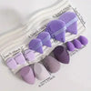 Un ensemble de tampons de maquillage et d'éponges en poudre à plusieurs faces dans diverses nuances de violet et de lilas, pr