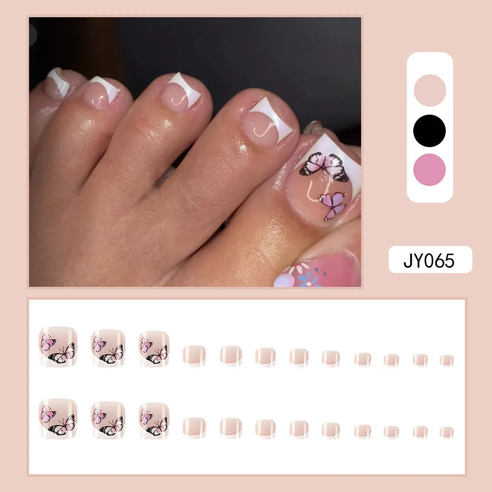 Eine Hand zeigt einen Satz wiederverwendbarer, künstlicher Zehennägel mit zarten rosa und lila floralen Designs.