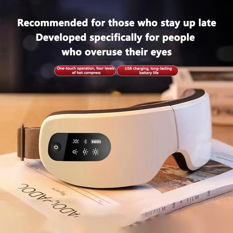 A white smart eye massager device is shown resting on a stack of papers.