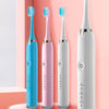 Un juego de cepillos de dientes eléctricos inteligentes en azul, rosa y blanco sobre una base circular rosa.