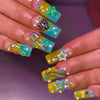 A hand displays Y2K sweet stars press-on nails featuring a blue and brown French wave design with glitter accents.