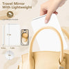 A hand holds a white travel mirror with a light weight, showing its size and portability.