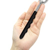A hand holds a small, flexible metal bear claw back scratcher and massager tool.