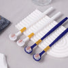 Ein Set aus drei weichen Borstenzahnbürsten in Weiß und Blau mit gelben Akzenten, auf einer weißen Unterlage.