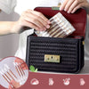 A hand is placing disposable medical iodine cotton swabs into a black leather storage case.