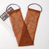 A brown exfoliating body scrub sponge made of net material with purple string for hanging.