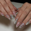Nahaufnahme einer Hand, die elegante nude und silberne Glitzer-Press-on-Falschnägel mit Blumenmustern zeigt.