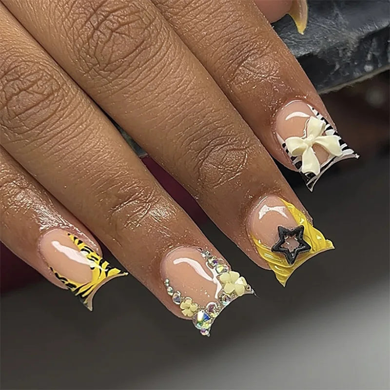 Nude pink press-on nails featuring a leopard print design and three-dimensional floral and star charms.