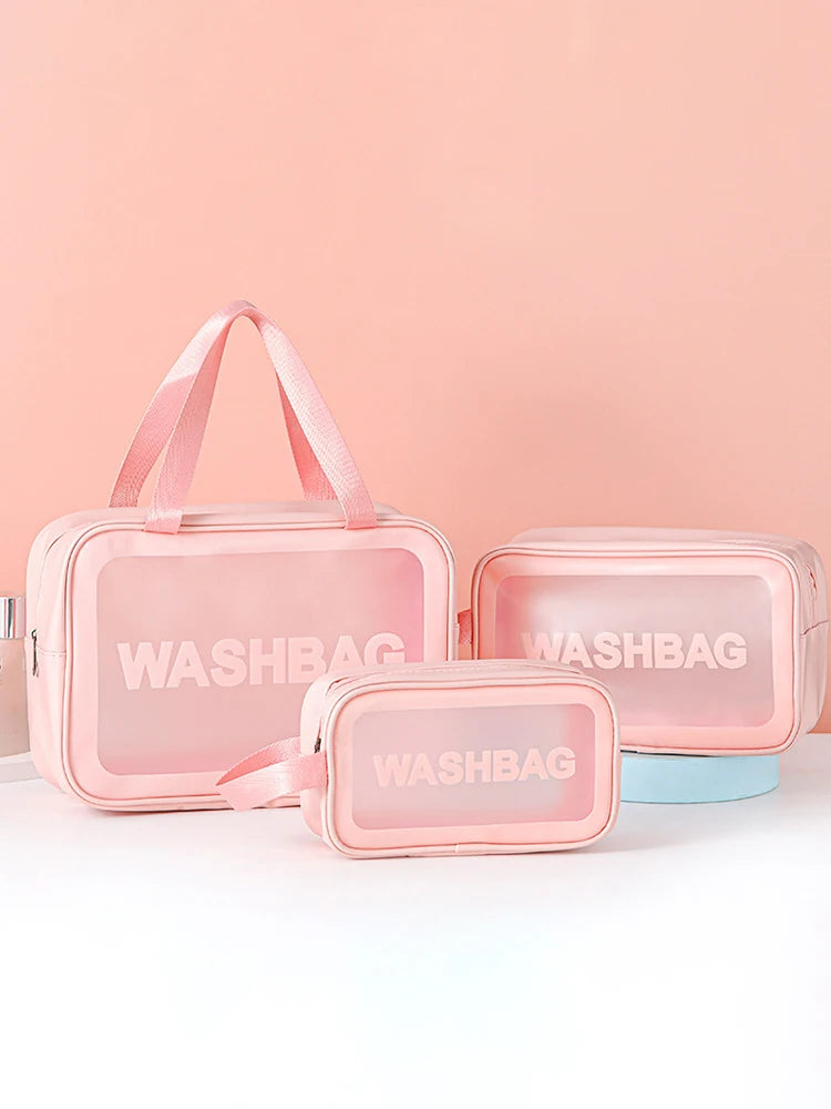 A set of pink transparent PVC cosmetic storage bags with pink straps and a light blue base.