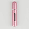 A sleek, cylindrical portable refillable perfume bottle in a rose gold color.