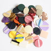 A collection of various colored beauty puffs and applicators arranged in a circular pattern.