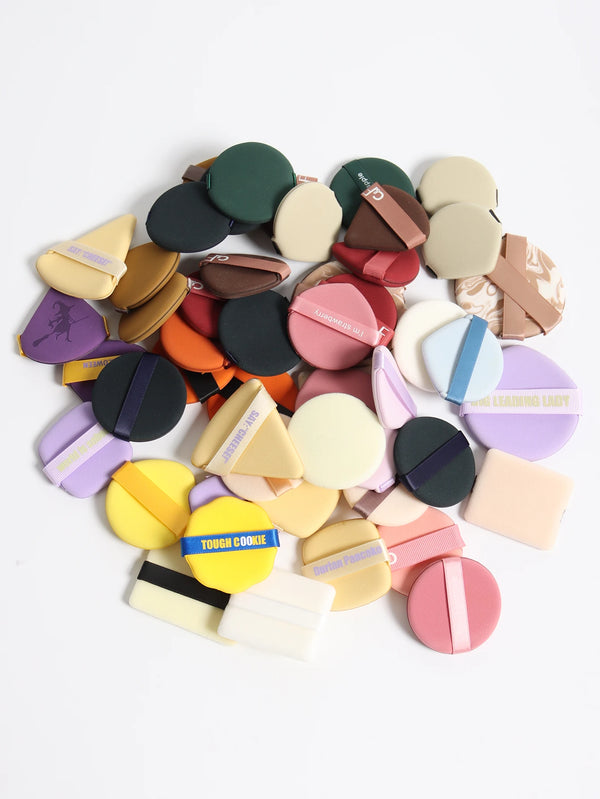 Collection de puff et applicateurs de beauté de différentes couleurs arrangés en cercle.