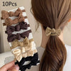 Un juego de 10 penyos de cabello dulces en varios tonos de marrón y beige siendo colocados en una coleta femenina.
