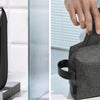 A hand is holding a black Kenzen electric body hair trimmer and a gray carrying case.