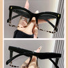 A pair of black demi sunglasses with tortoise shell accents shown in a close-up view.
