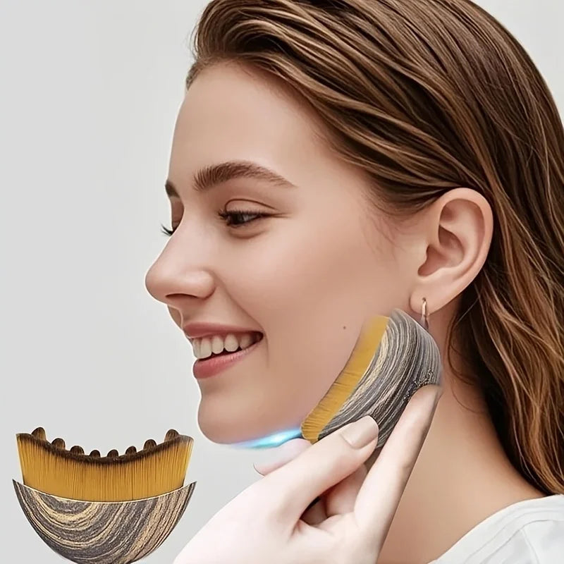 A woman is using a wooden lymphatic contour face brush on her cheek.