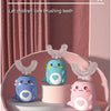 A display of three U-shaped electric toothbrushes for children with cute cartoon designs on a pink cake stand.