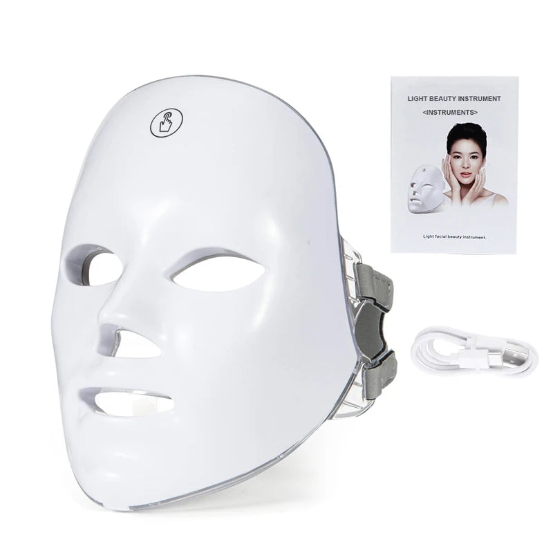 A white LED facial therapy mask with a silicone strap and accompanying power cord.