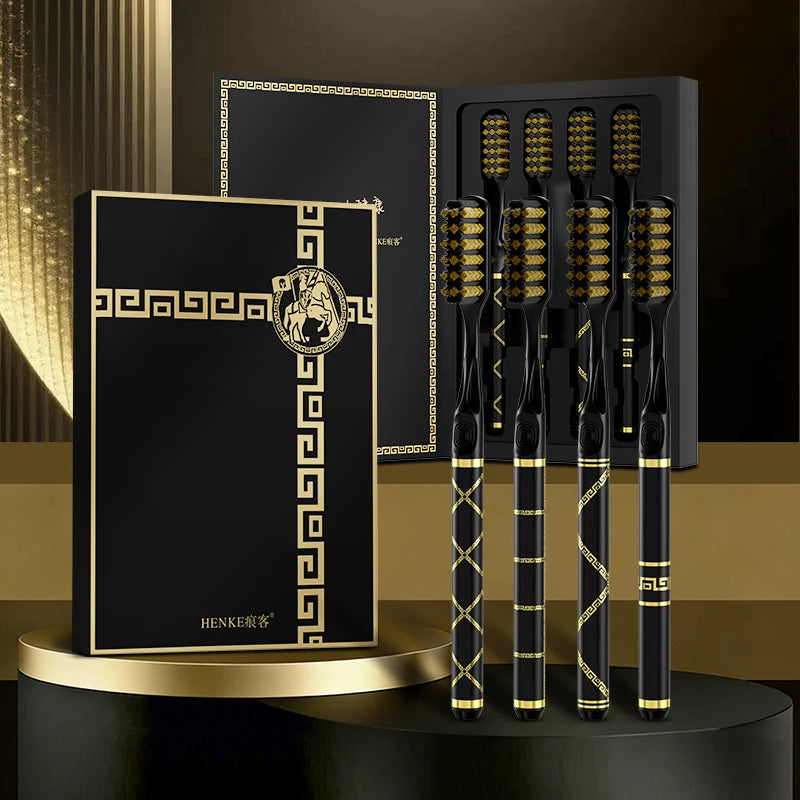 A set of black and gold soft bristle toothbrushes displayed in a packaging box on a dark surface.